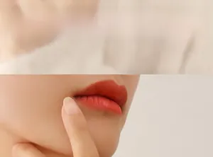 Close-up of matte orange-red lipstick on lips with a sleek 18K gold plated steel ring