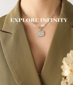 Détail d'un collier vintage à pendentif carré avec fleur et chaîne Figaro chic