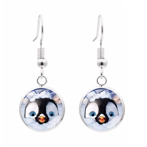 Gros plan détaillé de boucles d'oreilles pingouin en verre et métal argenté brillant