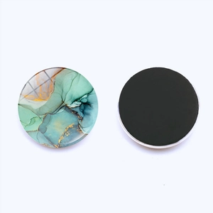 Detail van een ronde 25mm glazen koelkastmagneet met marmerpatroon en magneetzijde
