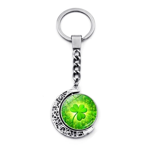 Close-up of double-sided rotating glass moon pendant with green lucky four-leaf clover