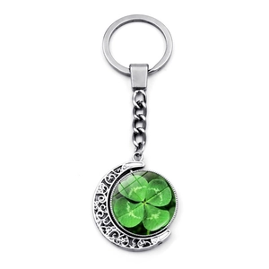Silver rotating crescent moon keychain with lucky green four-leaf clover glass pendant