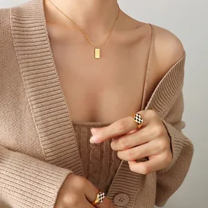 Gold snake chain necklace with Love pendant and checkerboard heart ring set on model