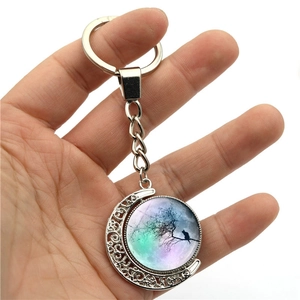 Rotating crystal moon keychain with tree branch cat illustration in silver frame