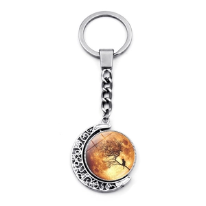 Rotating crystal moon keychain with black cat and tree branch design in silver frame