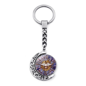 Detail of rotating moon pendant featuring stained glass dove art on silver keychain