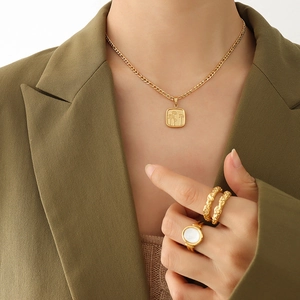Collier à pendentif fleur dorée et bague en nacre portés par un mannequin