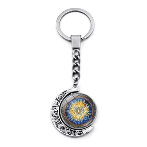 Detail of rotating moon pendant featuring stained glass style dove and scrollwork design
