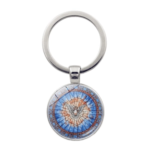 Gros plan sur un pendentif colombe en vitrail coloré monté sur un porte-clés en métal