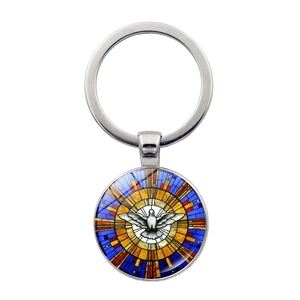 Gros plan d'un pendentif colombe en verre coloré avec porte-clés en métal argenté poli