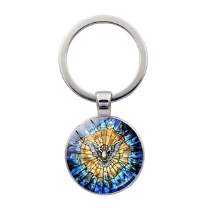 Détail du pendentif colombe en verre coloré sur porte-clés argenté au motif bleu et doré