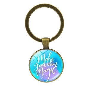 Portachiavi vintage in bronzo con ciondolo in vetro Make Your Own Magic su bianco
