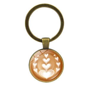 Antique bronze keychain featuring a latte art coffee heart pattern under glass dome