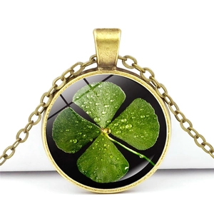 Detailed close-up of a vintage bronze clover glass pendant with realistic dewdrop details