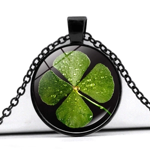 Close-up of green four-leaf clover crystal glass pendant necklace with black metal frame
