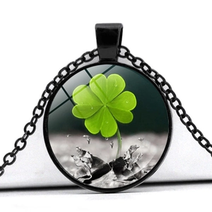 Crystal glass four-leaf clover pendant necklace with black metal frame on white background