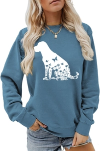 Détail de la silhouette de chien blanc aux motifs floraux sur un sweat-shirt bleu col rond