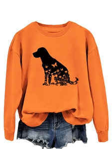 Détail du sweat orange à col rond avec imprimé silhouette de chien aux motifs floraux