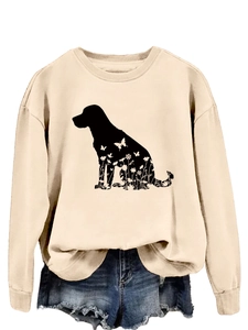 Détail du sweat-shirt beige abricot avec silhouette de chien fleurie et poignets côtelés