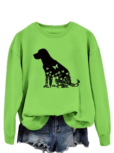 Détail d'un sweatshirt vert vif avec silhouette noire de chien et motifs floraux