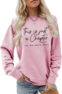 Close-up of pink crewneck sweatshirt with this is just a chapter slogan print