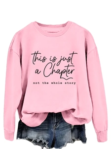 Detail of pink crewneck sweatshirt featuring black inspirational text and ribbed cuffs