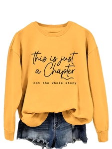 Detail of yellow sweatshirt featuring This is just a Chapter print and ribbed round neck