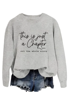 Close-up of inspirational black text printed on a soft grey long sleeve sweatshirt