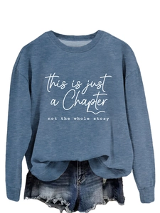 Close-up of fog blue sweatshirt featuring This is just a Chapter white printed text