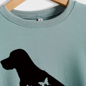 Sweat-shirt vert sauge à col rond avec silhouette de chien et imprimé papillon sur cintre