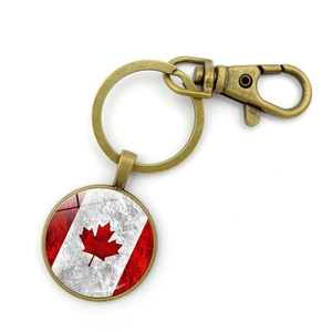 Close-up of vintage bronze Canada flag keychain with maple leaf and lobster clasp