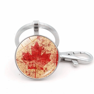 Close-up of vintage metal keychain with red Canada maple leaf pendant and lobster clasp