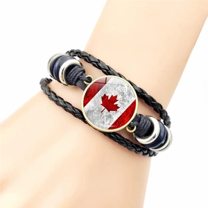 Handcrafted Canada flag leather bracelet featuring maple leaf glass charm on a black woven band