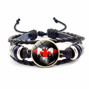 Close-up of Canada flag glass dome on multi-layer braided leather bracelet