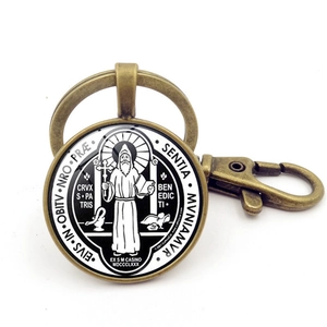 Macro detail of vintage bronze Saint Benedict Medal keychain with glass cabochon insert