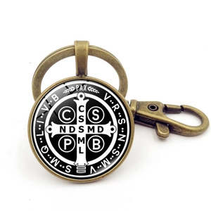 Detail of vintage bronze Saint Benedict Medal keychain with glass cabochon and lobster clasp