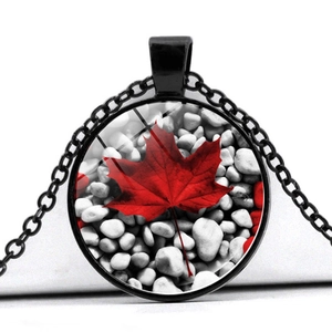 Macro shot of circular Canada maple leaf glass pendant necklace with black metal chain