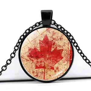 Macro detail of Canada flag necklace pendant with red maple leaf and antique texture