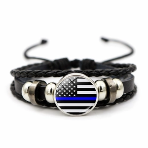 Detailed view of multilayer braided leather USA flag bracelet with thin blue line charm