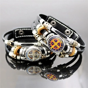 Detailed view of Saint Benedict Medal leather bracelets with wood beads and silver charms