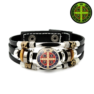 Detail of multi-layer leather bracelet with luminous St. Benedict medal and wood beads