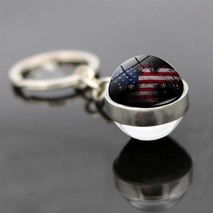 Vista detallada del llavero de bola de cristal de doble cara bandera USA sobre espejo negro