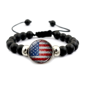 Macro view of American flag glass charm on black matte beaded adjustable bracelet