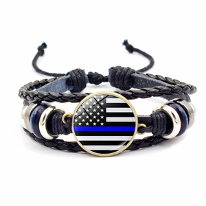 Detail of multi-layer braided leather bracelet with Thin Blue Line flag glass charm