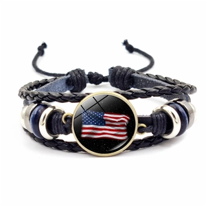 Detail of multi-layer woven leather bracelet with USA flag glass charm and adjustable cord