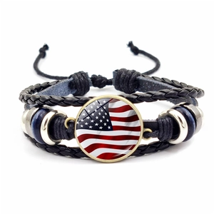 Detail of multi-layer braided leather bracelet featuring USA flag glass dome and beads