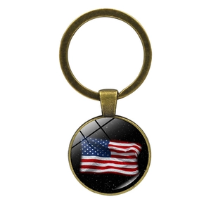 Detail of vintage bronze keychain featuring US flag under glass cabochon on white background