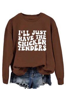 Detailed view of white slogan print on brown sweatshirt with denim shorts outfit