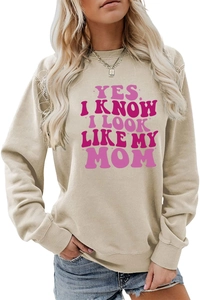 Close-up of pink text print on a beige long sleeve crewneck sweatshirt for women