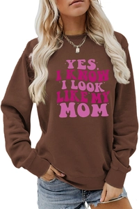 Detail of a brown sweatshirt featuring the pink slogan Yes I Know I Look Like My Mom